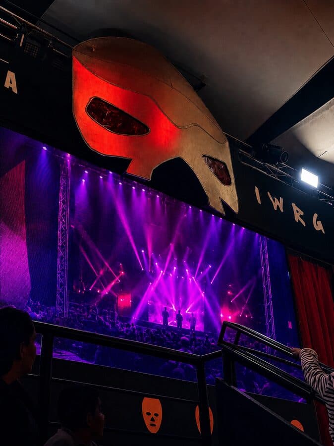 Escenario con máscara gigante y luces en Arena Naucalpan